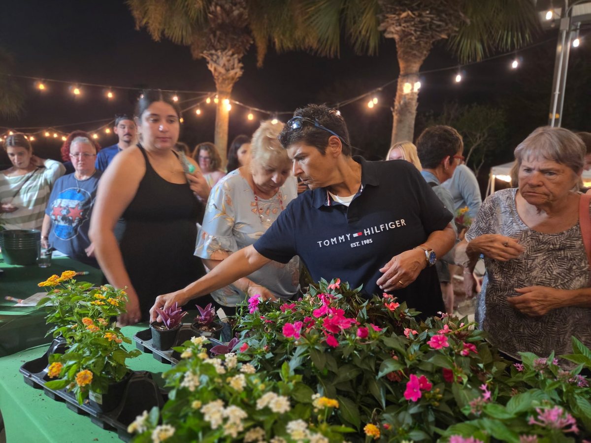 Guests choosing their plants from a table full of flowers at the end of the night
